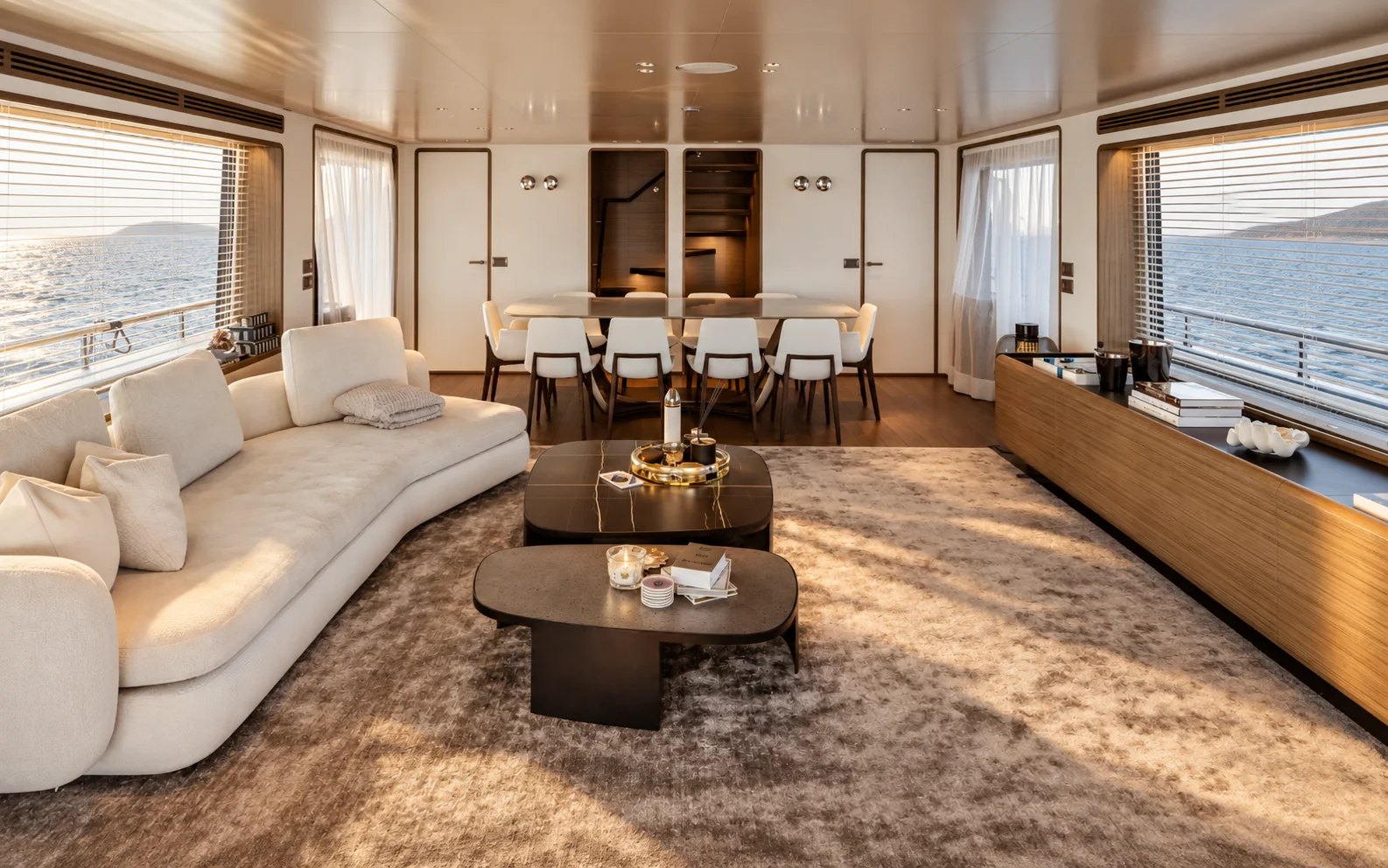 LAVAN's main saloon, with a curved cream sofa, walnut floor and the dining table beyond