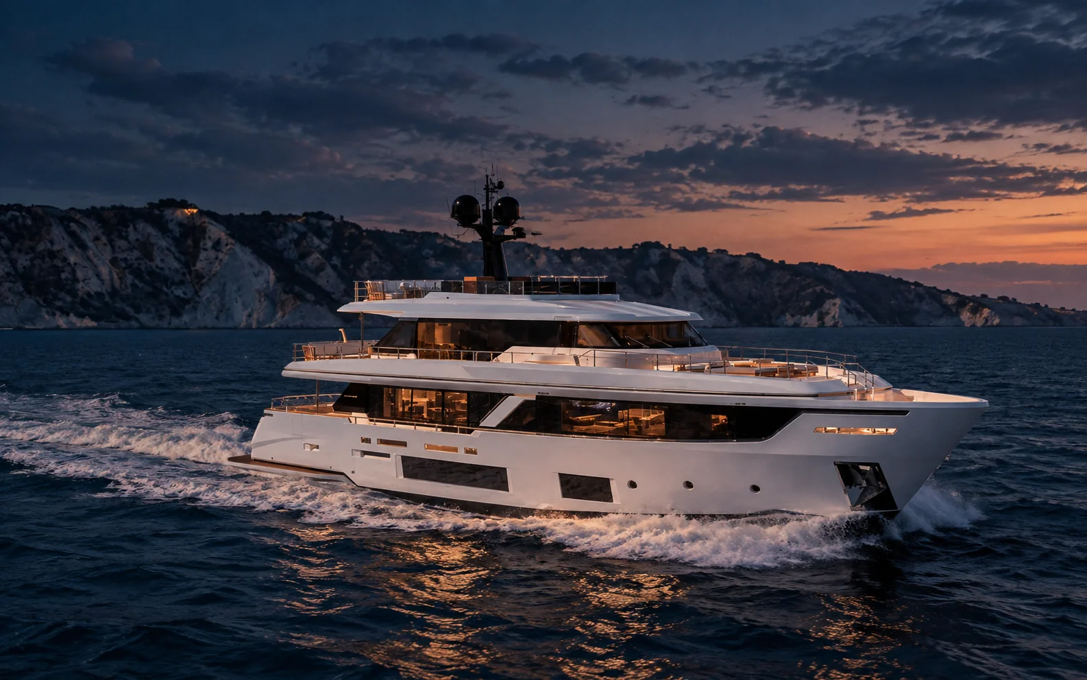 LAVAN, a Custom Line Navetta 30, under way in profile along a rocky coastline
